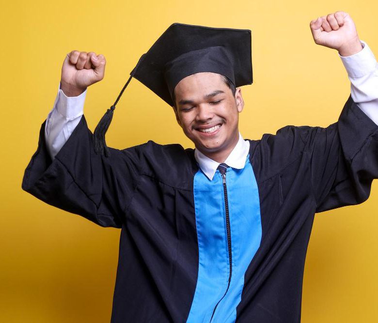 A student in convocation gown celebrating