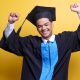 A student in convocation gown celebrating